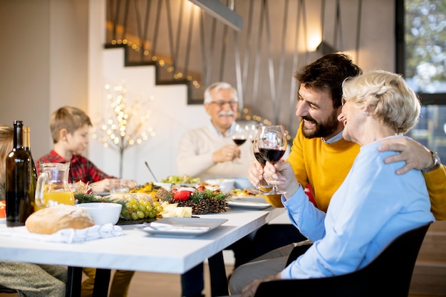 家で赤ワインと夕食を食べている幸せな家族