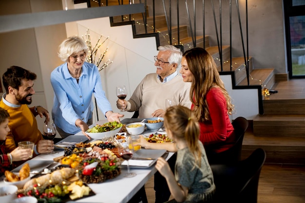 Happy family having a dinner with red wine at home