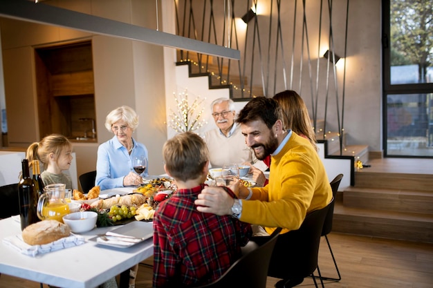 Happy family having a dinner with red wine at home