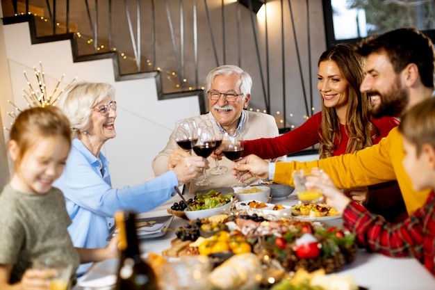 Happy family having a dinner with red wine at home