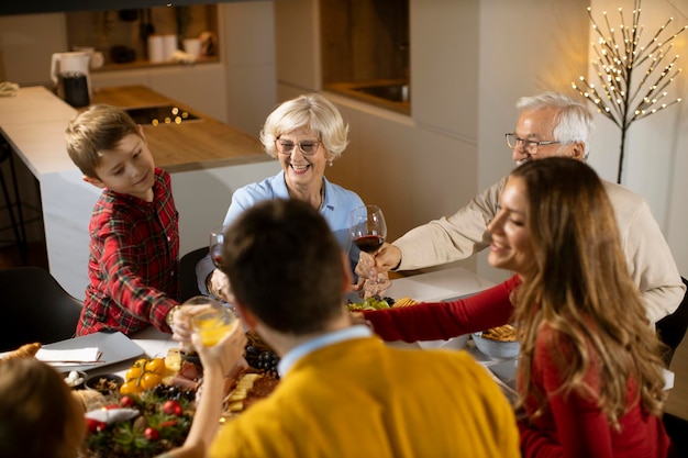 Foto famiglia felice che cena con vino rosso a casa