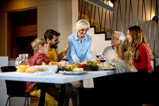 Foto famiglia felice che cena con vino rosso a casa