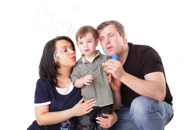 Happy family having fun. Father, mother and child blow bubbles. Series