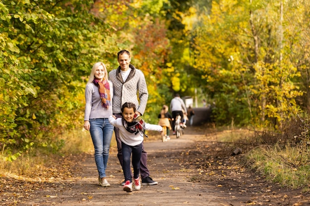 흐릿한 나뭇잎 배경을 배경으로 가을 공원에서 야외에서 즐거운 시간을 보내는 행복한 가족