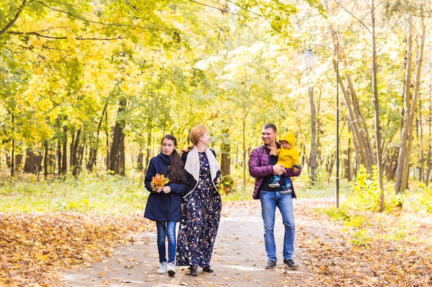 Счастливая семья весело на открытом воздухе в осеннем парке