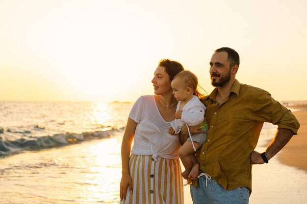 Happy family having fun playing beach in summer vacation on the beach Happy family and vacations concept Seascape at sunset with beautiful sky Family on the beach