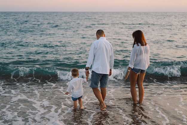 Happy family having fun playing beach in summer vacation on the beach Happy family and vacations concept Seascape at sunset with beautiful sky Family on the beach