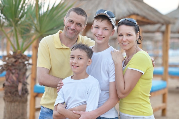 Счастливая семья, развлекающаяся на качелях на тропическом курорте