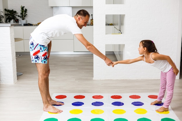 happy family having fun together, playing twister game at home