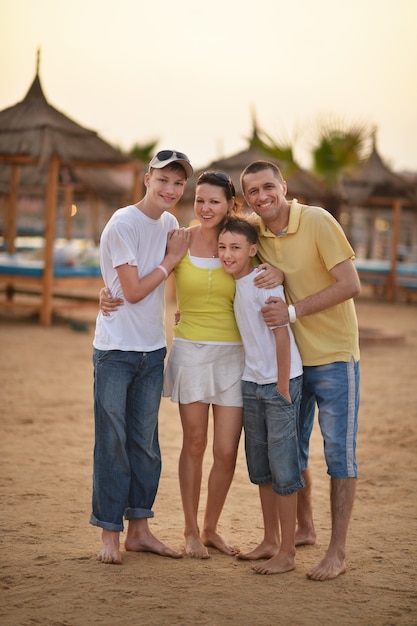 Счастливая семья весело на тропическом курорте на закате