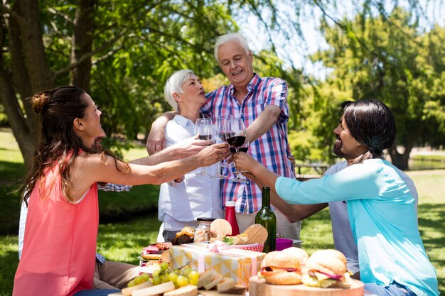 Happy family having red wine in park