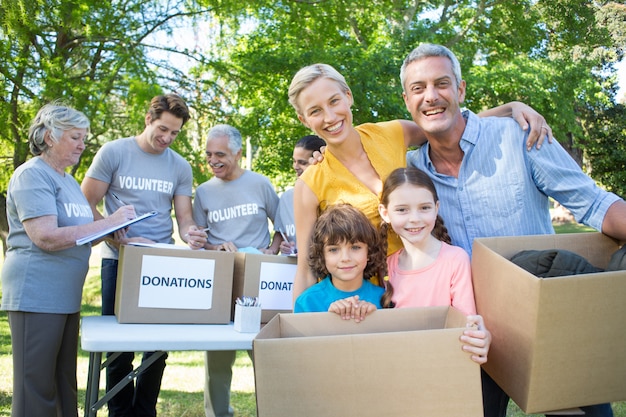 Photo happy family holding boxes and smiling at the camera