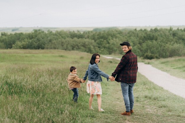 Happy family holding by hands looking at camera