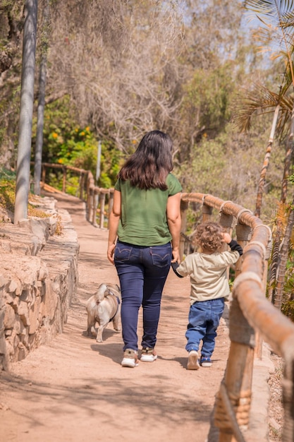 Happy family holding hands and walking through park on the afternoon