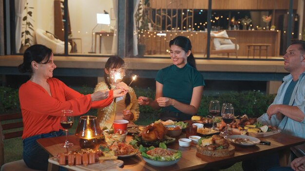 happy family holding sparkler in holiday celebration party at night divergence