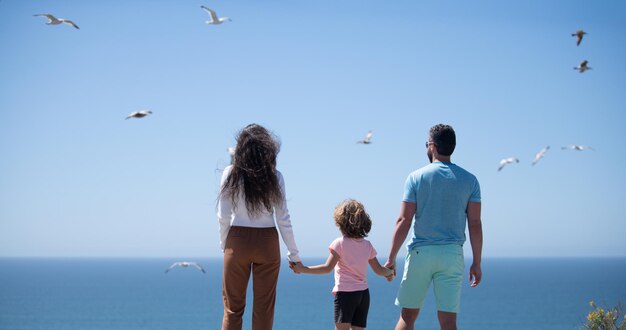 Happy family holidays joyful father mother baby son walk of sea sand beach active parents and people