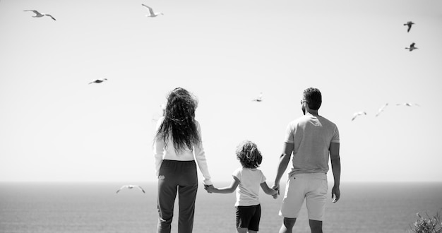 Счастливых семейных праздников, радостный отец, мать, сын, прогулка по морскому песчаному пляжу, активные родители и люди