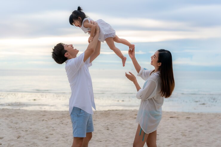 うれしそうな父、母と娘が歩いている間に幸せな家族の休日と娘を育てる