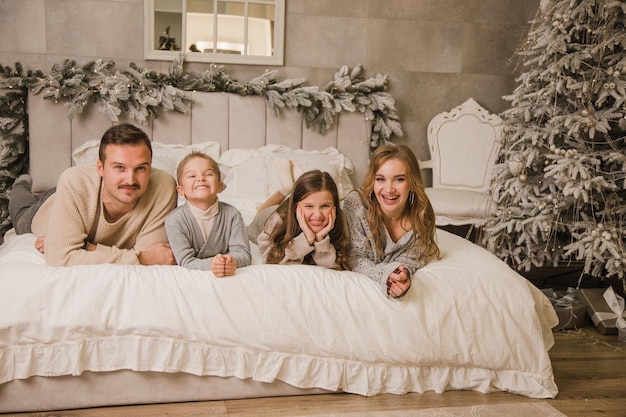 Foto famiglia felice a casa sul letto concetto di nuovo anno