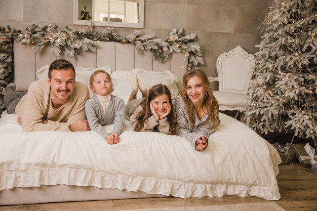 Foto famiglia felice a casa sul letto concetto di nuovo anno