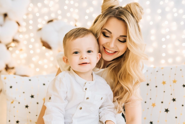 Happy family at home in front of the tree. Beautiful mother and child are preparing for the new year holidays