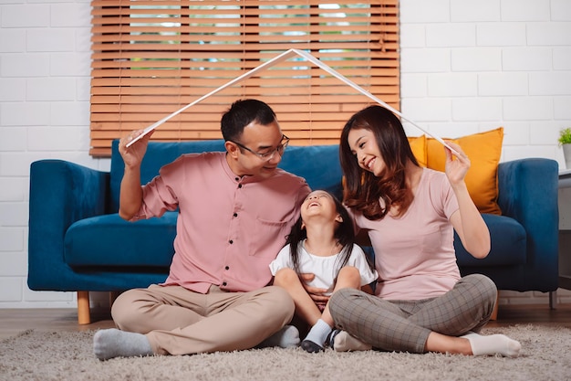 happy family home insurance roof protecting house and daughter holding cardboard covering for family protection