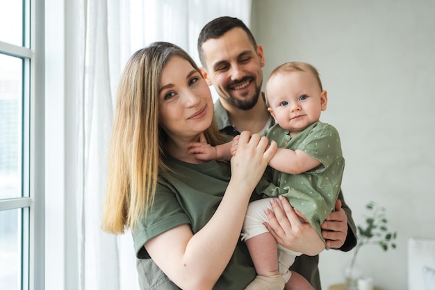 happy family at home mother father holding little toddler child mom dad baby girl relax playing having fun together woman man hugging embracing baby with love care parent of breast feeding baby