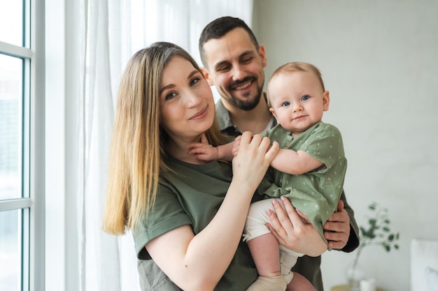 Happy family at home Mother father holding little toddler child Mom dad baby girl relax playing having fun together Woman man hugging embracing baby with love care Parent of breast feeding baby