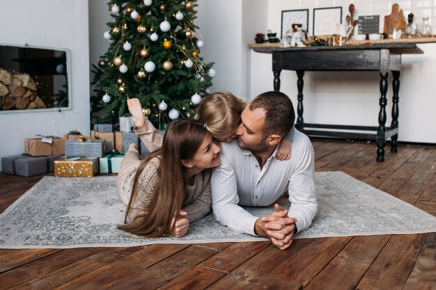 Happy family at home near Christmas tree and Christmas presents