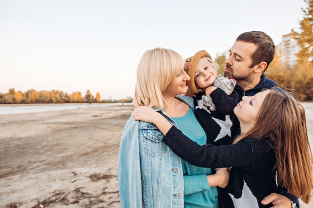 Happy family hugs by the river