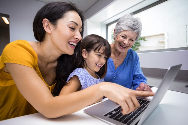 Famiglia felice che interagisce con il computer portatile