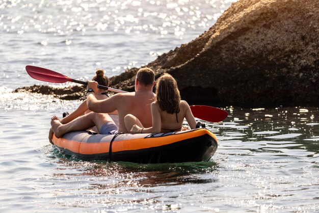 Happy family is enjoying paddling in kayak at tropical sea water during summer vacation