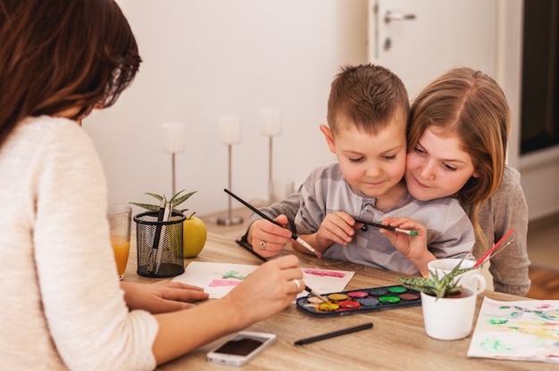 Happy family is painting on paper