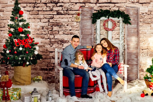 Happy family is sitting on a bench in the holiday scenery