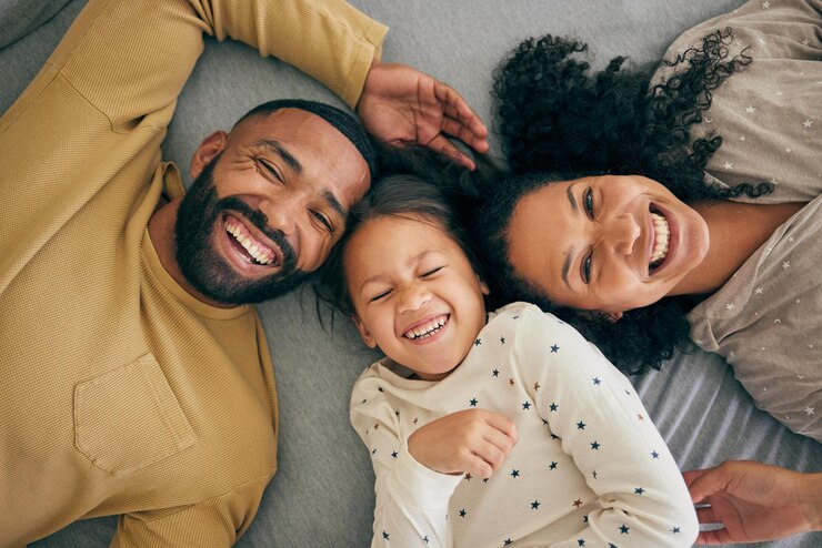 Photo happy family above and kid smile or happy with parents together in the morning laughing in a bedroom on a bed relax mom and dad enjoy quality time with kid with happiness bonding and love