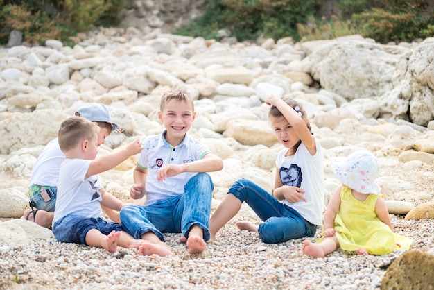 Happy family kids standing on a wood pontoon in front of the sea in summertime.