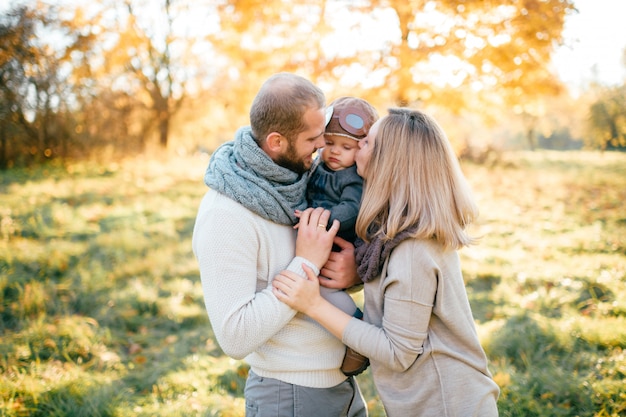 Happy family kissing  their child at nature