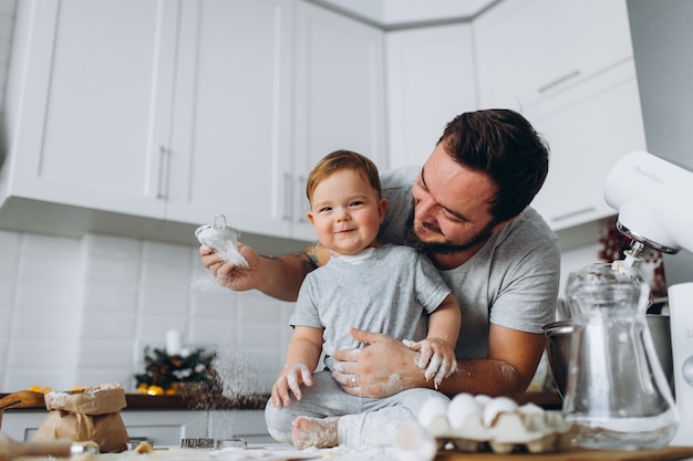 Happy family in the kitchen. father and son preparing the dough, bake cookies