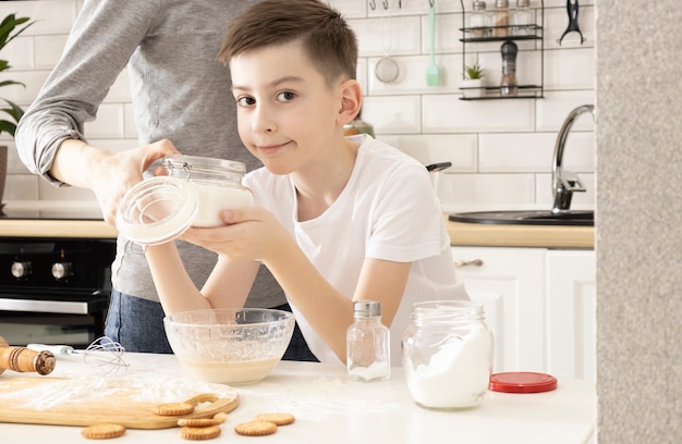 Famiglia felice in cucina. madre e bambino che preparano la pasta, cuocere i biscotti