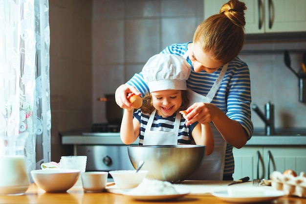 Happy family in kitchen mother and child preparing dough bake cookies