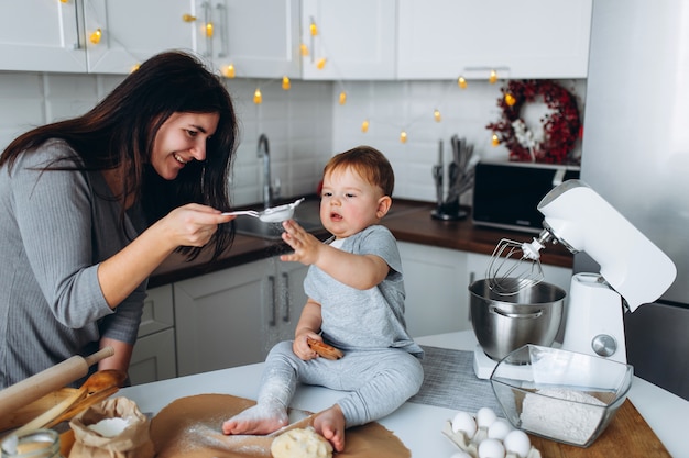 Happy family in the kitchen. mother and son preparing the dough, bake cookies