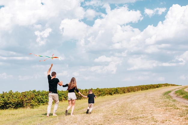 La famiglia felice lancia un aquilone sulla natura.