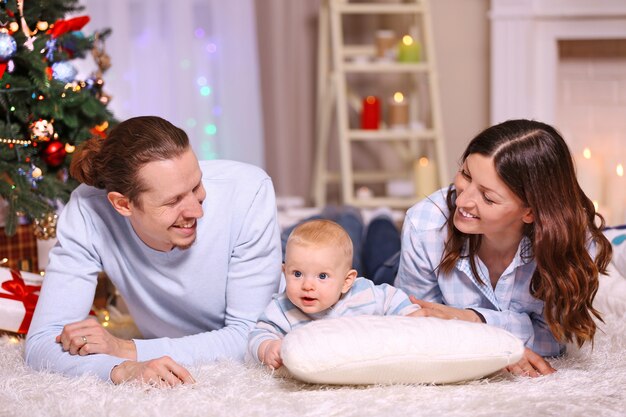 Happy family laying on the floor in the decorated Christmas room