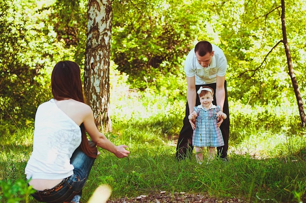 Photo happy family lifestyle and holiday. mother, father, little girl walking in city, green park. fun