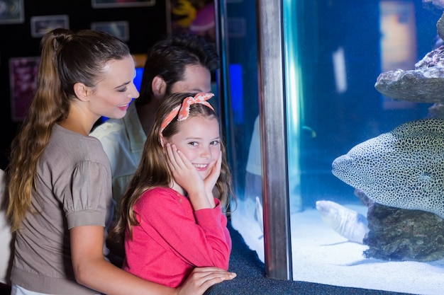 Happy family looking at fish tank