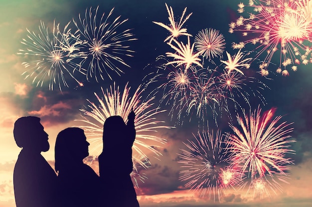 the happy family looks holiday fireworks in the evening sky