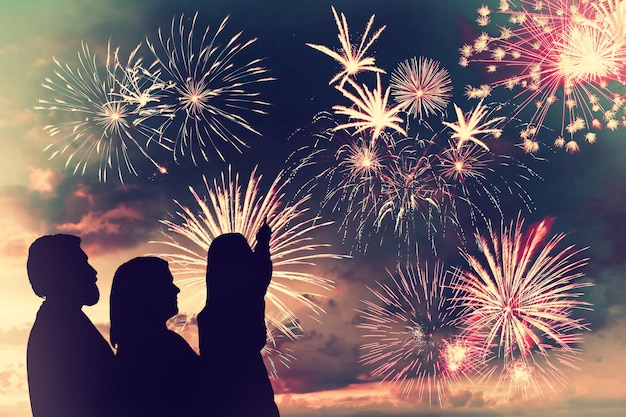 La famiglia felice guarda i fuochi d'artificio delle vacanze nel cielo della sera