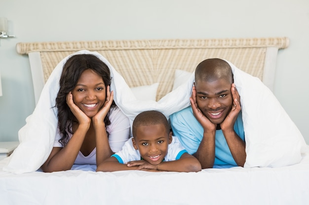 Famiglia felice sdraiata sul letto