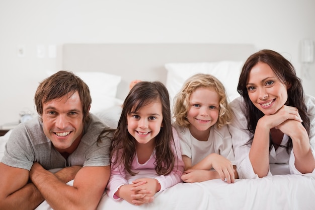 Happy family lying in a bed