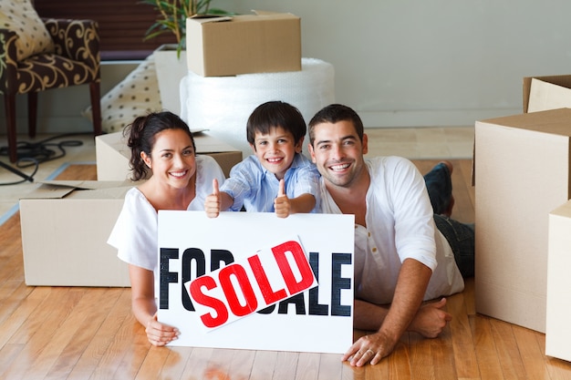 Happy family lying on the floor after buying house